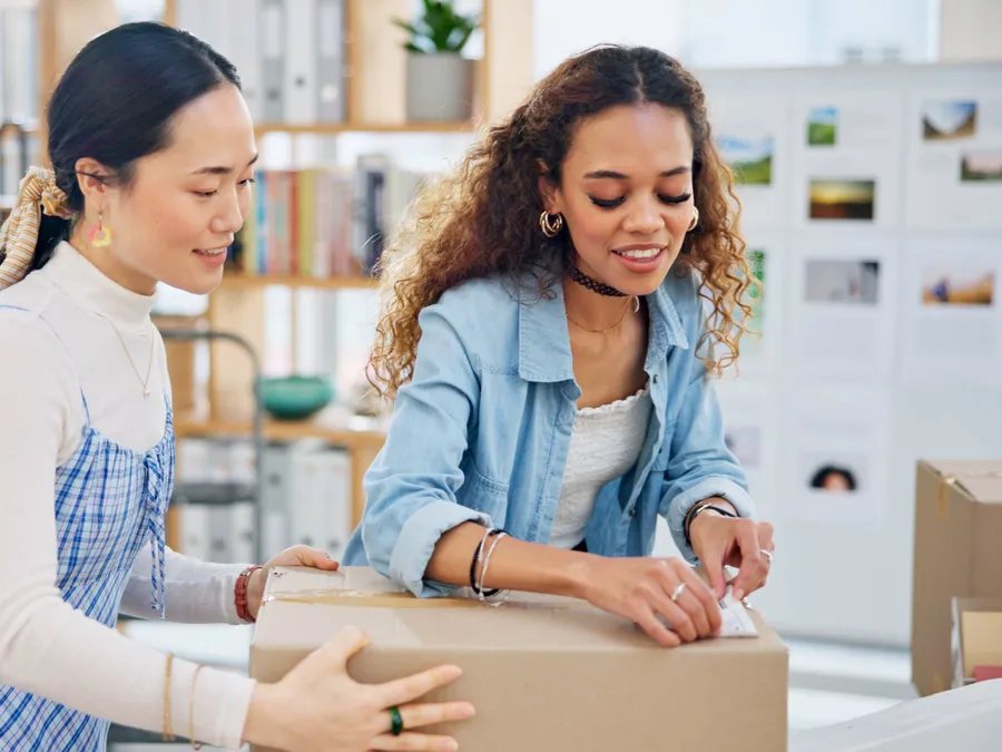 A two-person team packing online orders together in an atelier (illustrative photo)